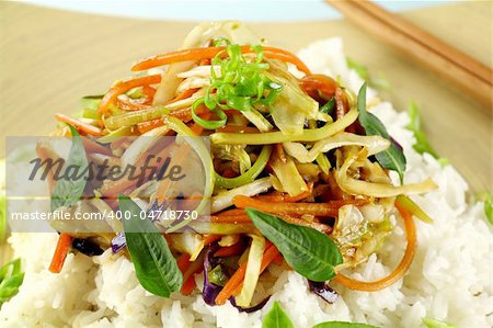 Delicious vegetarian asian stir fry on boiled white rice with thai basil and vietnamese mint.