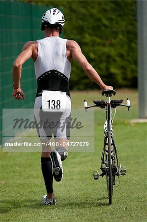 Triathlete pushing his bike in the transition zone
