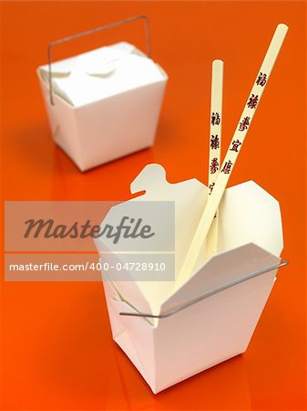 A Chinese takeaway container isolated against an orange background