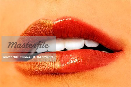 Macro image of bright lips. Red and gold lipstik