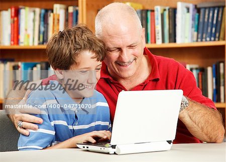 Father and son in the library using a small netbook computer.