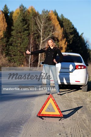 Woman trying to catch someone who may help her. Focus is intentionally located on the red triangle sign.