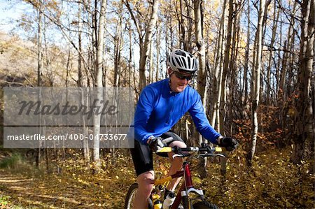 Mature man mountain biking on autumn day.