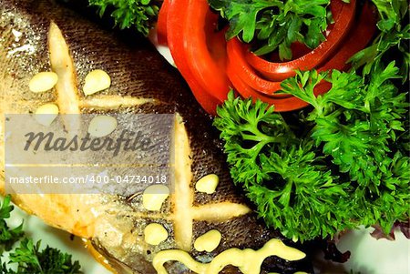 Stuffed baked fish served with  salad