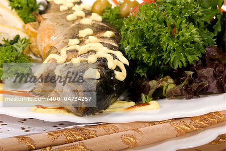 Stuffed baked fish served with salad