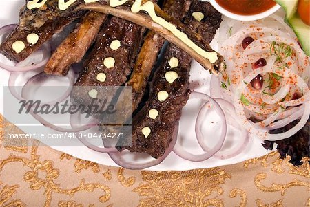 Fried ribs served with the rings of onion