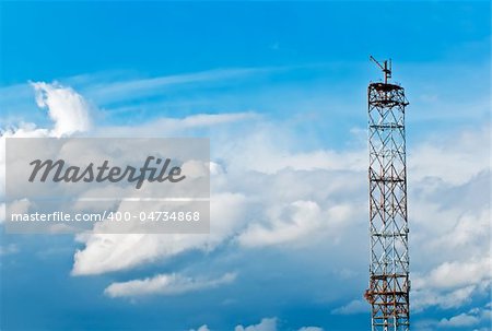 Antenna against the blue sky and clouds