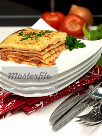 Freshly cooked lasagne plated up on a kitchen bench