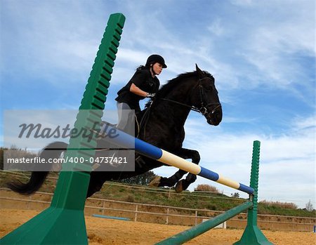 young teenager and her  horse in training of jumping competition