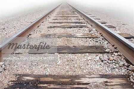 Low angle view of railway track disappearing into the mist