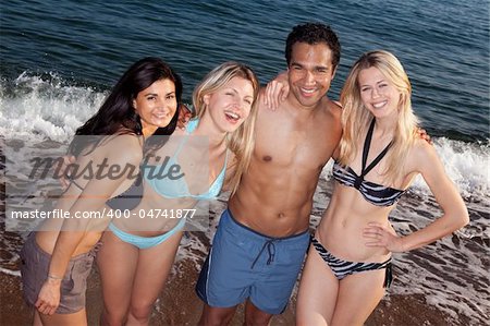 A group of friends smiling having fun at the beach