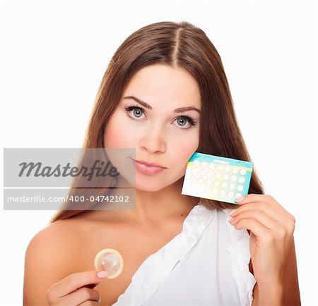 Pretty girl with condom and contraceptive pills. Isolated over a white background.