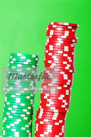 Stack of red and green casino chips against green background
