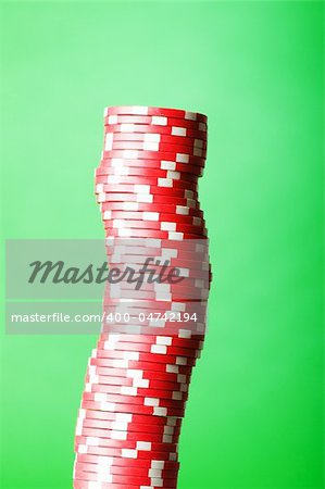 Stack of red casino chips against green background