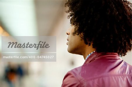 An African American man with afro looking away from the camera