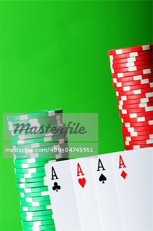 Casino chips and cards against green background