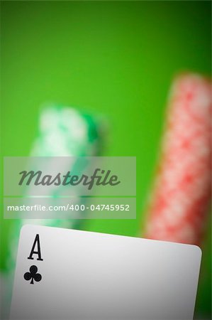 Casino chips and four aces against green background