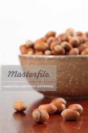 Bowl with hazelnuts on a wooden table. Shallow DOF