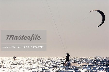 silhouette of a kitesurfer jumping in the waves