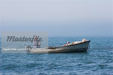 fishermen in a boat watching their nets