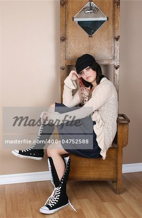 Beautiful brunette teen daydreaming, sitting on an antique coathanger