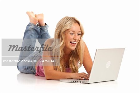 Portrait of casual young girl with jeans laying on floor with laptop