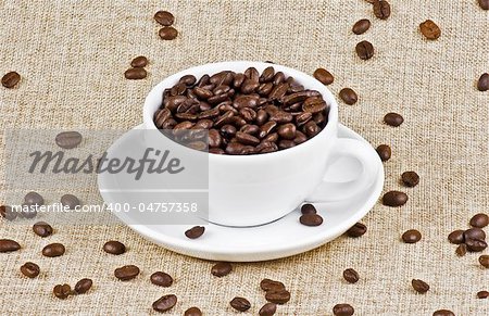 Cup of coffe beans on burlap bag