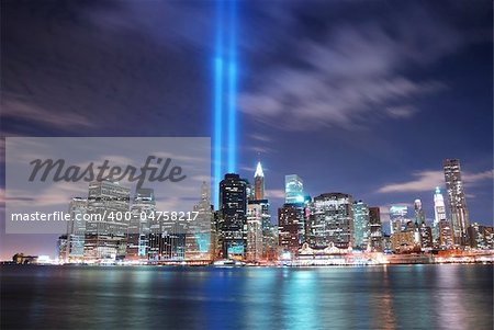 Remember September 11. New York City Manhattan panorama view at night with office building skyscrapers skyline illuminated over Hudson River and two light beam in memory of September 11.