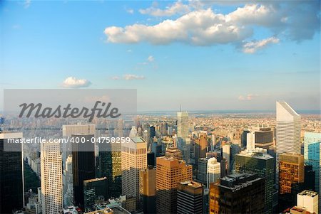 Aerial view of New York City at dusk with warm sunset color and cloud.