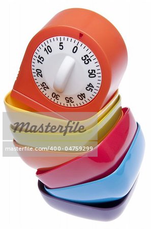 Kitchen timer on a falling stack of colorful bowls suggesting that it is time to get on a healthy diet.  Isolated on white with a clipping path.