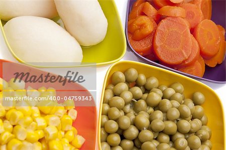 Vibrant Canned Vegetables Isolated on White close up.  Carrots, Corn, White Potatoes, and Peas.