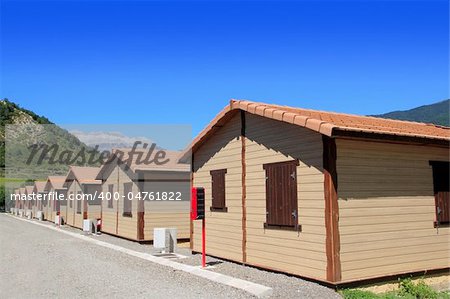 Wooden bungalow houses in camping area in Pyrenees mountains