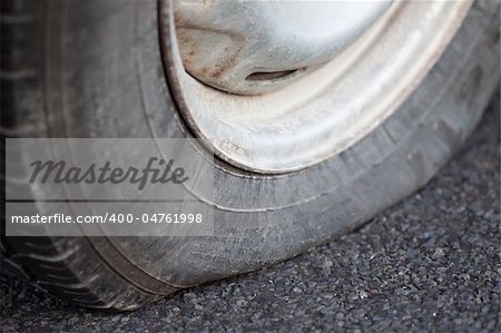 A closeup shot of a flat tire of a car