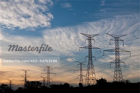 A long line of electrical transmission towers carrying high voltage lines.