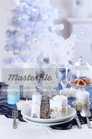 Place setting for Christmas in white  with white Christmas tree