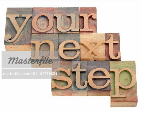 your next step - phrase in vintage wooden letterpress printing blocks isolated on white