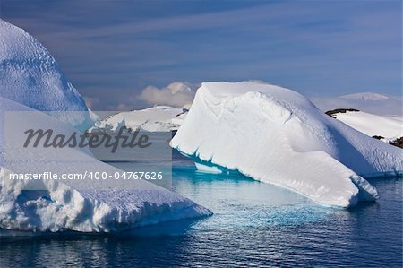 Huge icebergs in Antarctica, blue sky, azure water, sunny day