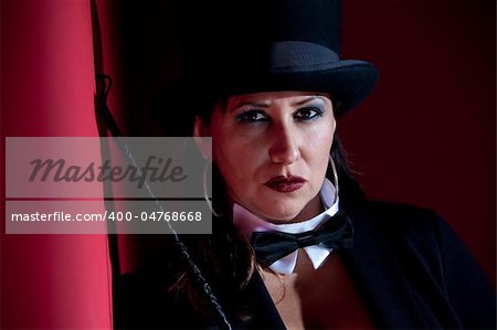 Woman dressed like a circus ringmaster with riding crop