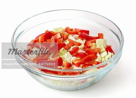 Healthy salad with vegetables in a stylish glass bowl isolated on white background