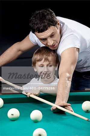 The young man with the son plays billiards