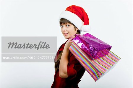 a beautiful young smiling girl in Santa hat with shopping