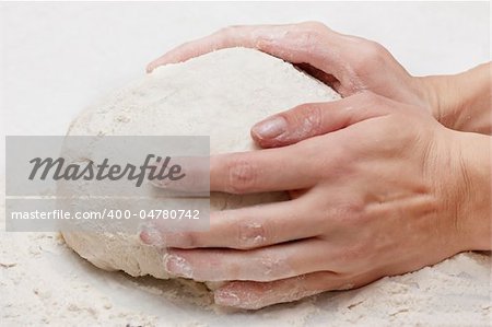 Pair of hands kneading pizza dough.