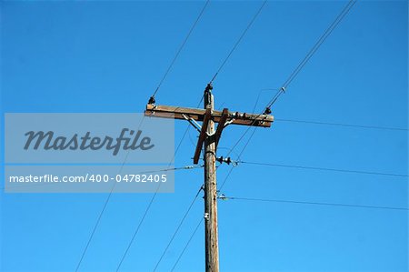 phone pole with land line against a blue sky
