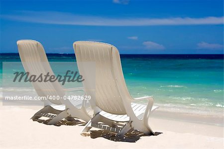 Two beach chairs on a clean, sunny beach. Maldives