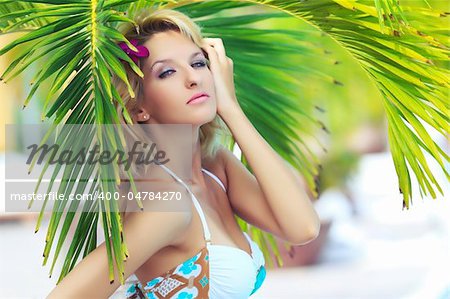 Portrait of a beautiful woman under palm tree