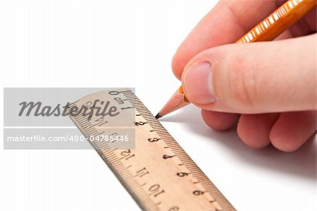 Hand draws a line with a pencil and ruler on a white background