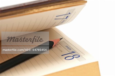 Pencil in an open diary on the white background