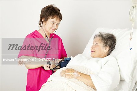 Nurse takes a senior patient's blood pressure in the hospital.