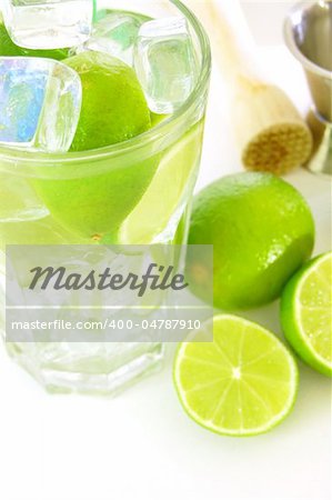 Caipirinha cocktail with green lemon and ice cubes