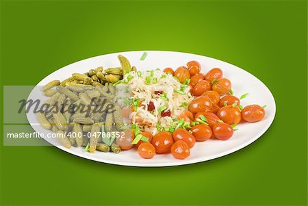 Marinated vegetables at the plate on a green background